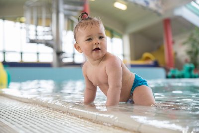 na zdjęciu małe dziecko na tle basenu